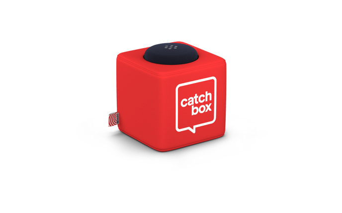 A red cube-shaped throwable microphone called Cube. The device has a black spherical foam cap on top and features the 'catchbox' logo in white on its side. It's designed for audience participation in events or meetings.